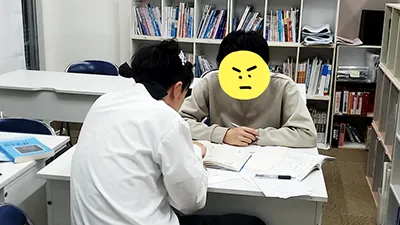 受験対策授業を専門とした経験豊富な講師に問題がわかるまで相談をしているシーン