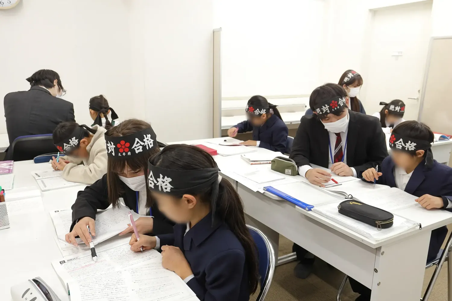 小学生のコースで講師から問題の解き方を習っているシーン