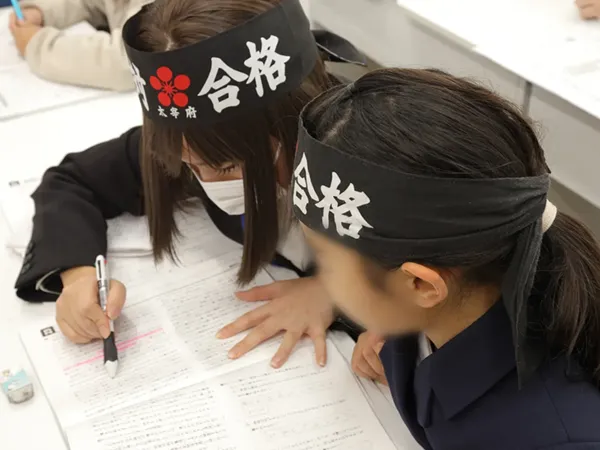わからない問題について講師に個別の解説を受けている中学生の塾生