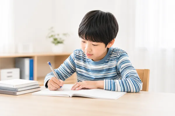 小学生が自宅で課題科目を解いているシーン
