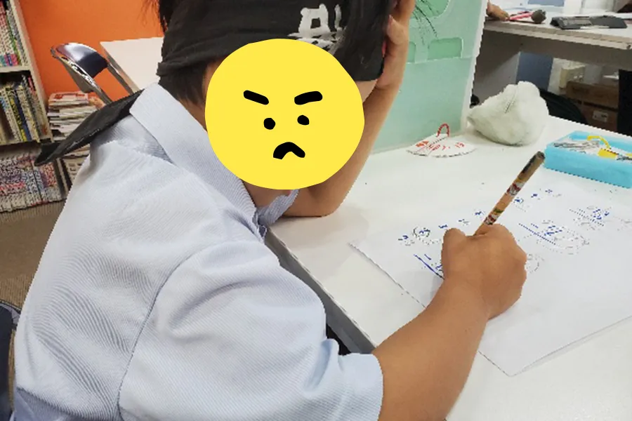 テスト結果について悩みながら勉強する子ども