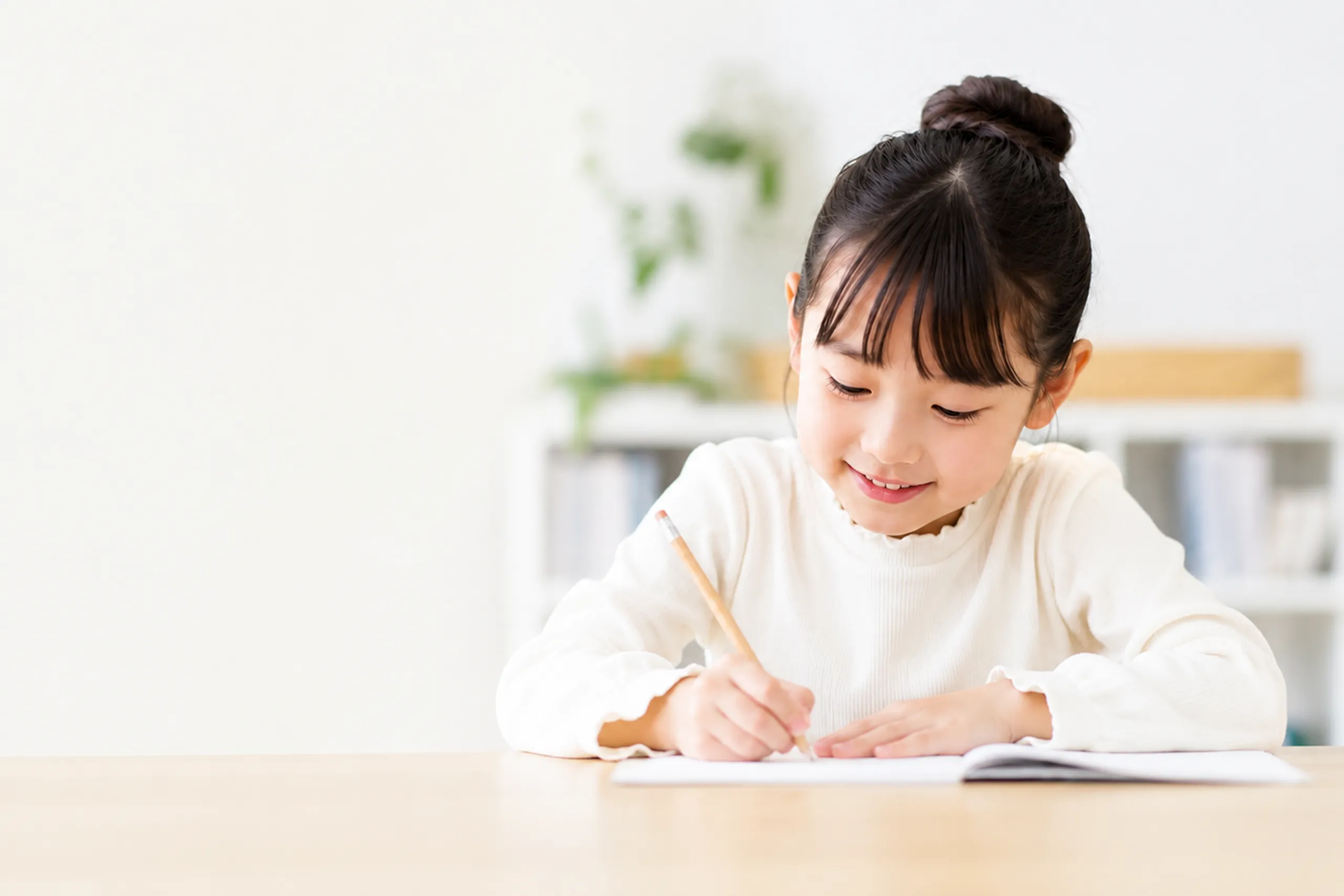 小学生の兄妹が塾で並んで勉強している様子